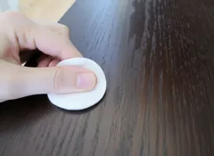 Kring van watten op donkere houten tafel om watervlek te verwijderen
