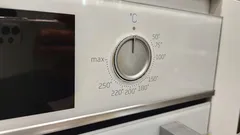 Dichtbijbeeld van een ovendeur met bedieningspaneel en draaiknop
