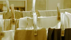 witte plastic kledinghanger aan bruine textiel waslijn