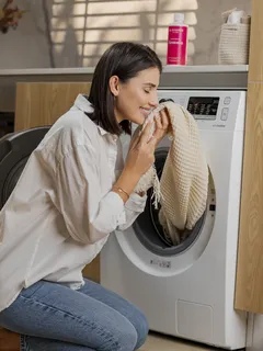 Vrouw zittend voor wasmachine op vloer