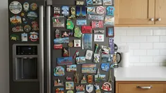 Koelkast volgekregen met kleurrijke magneten in een moderne keuken met houten kastjes.