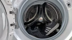 Grijze sneakers in een witte wasmachine